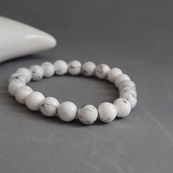 Fehér howlit karkötő szürke háttérrel